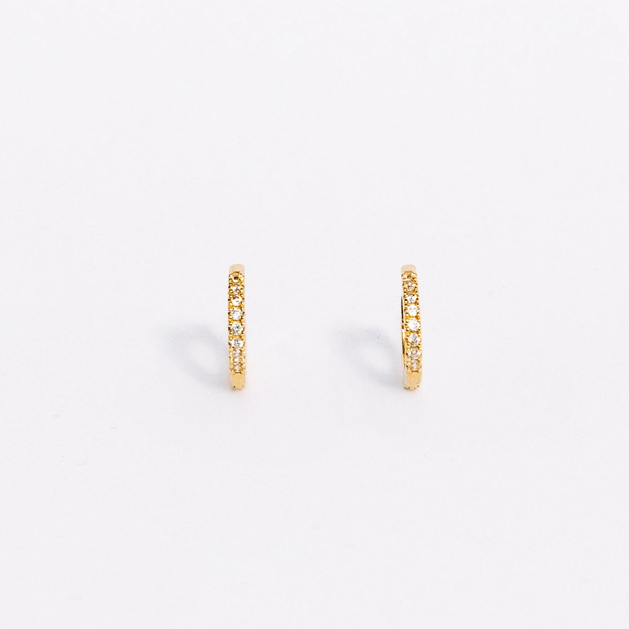 Gold hoop earrings on a light beige background