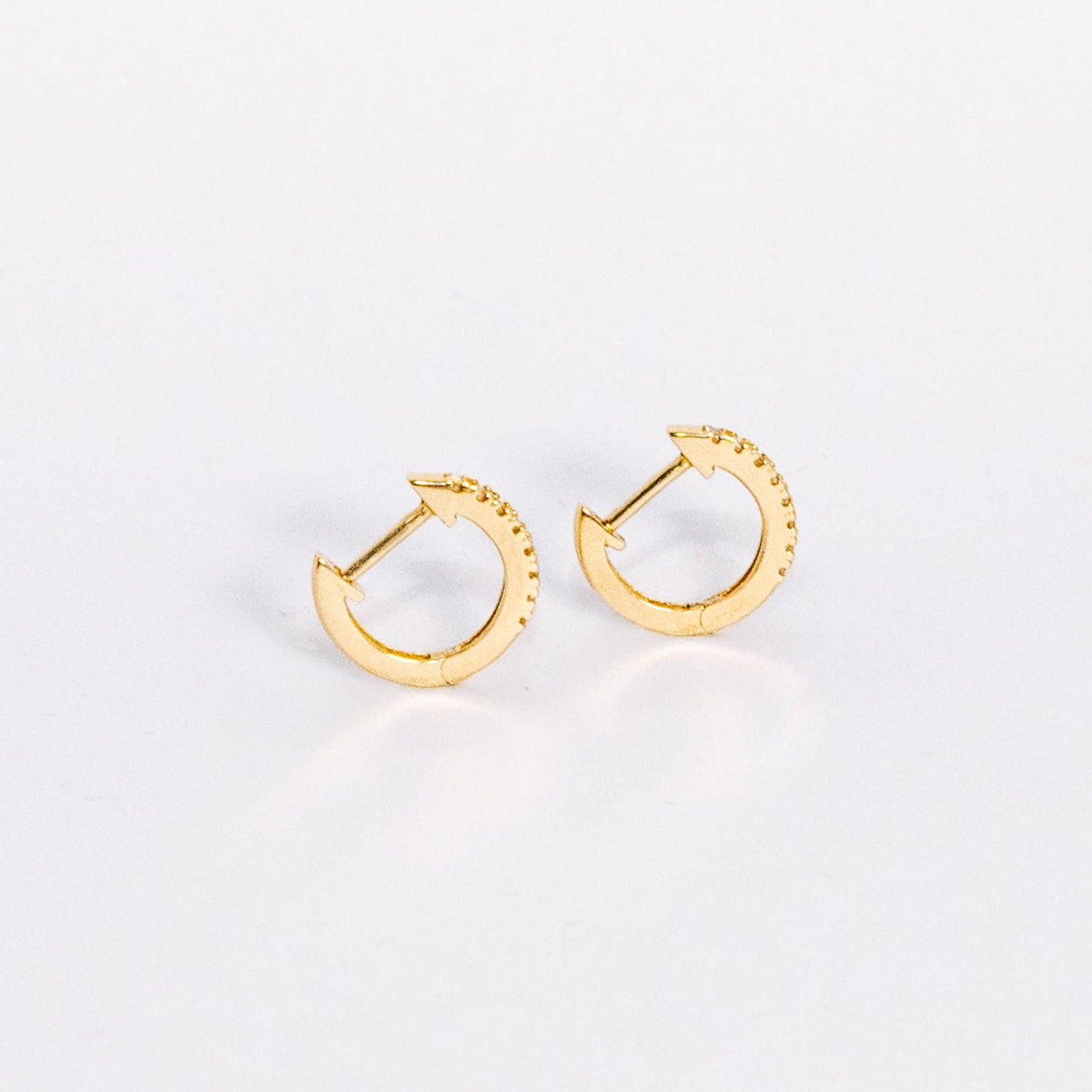 Gold hoop earrings on a light gray background