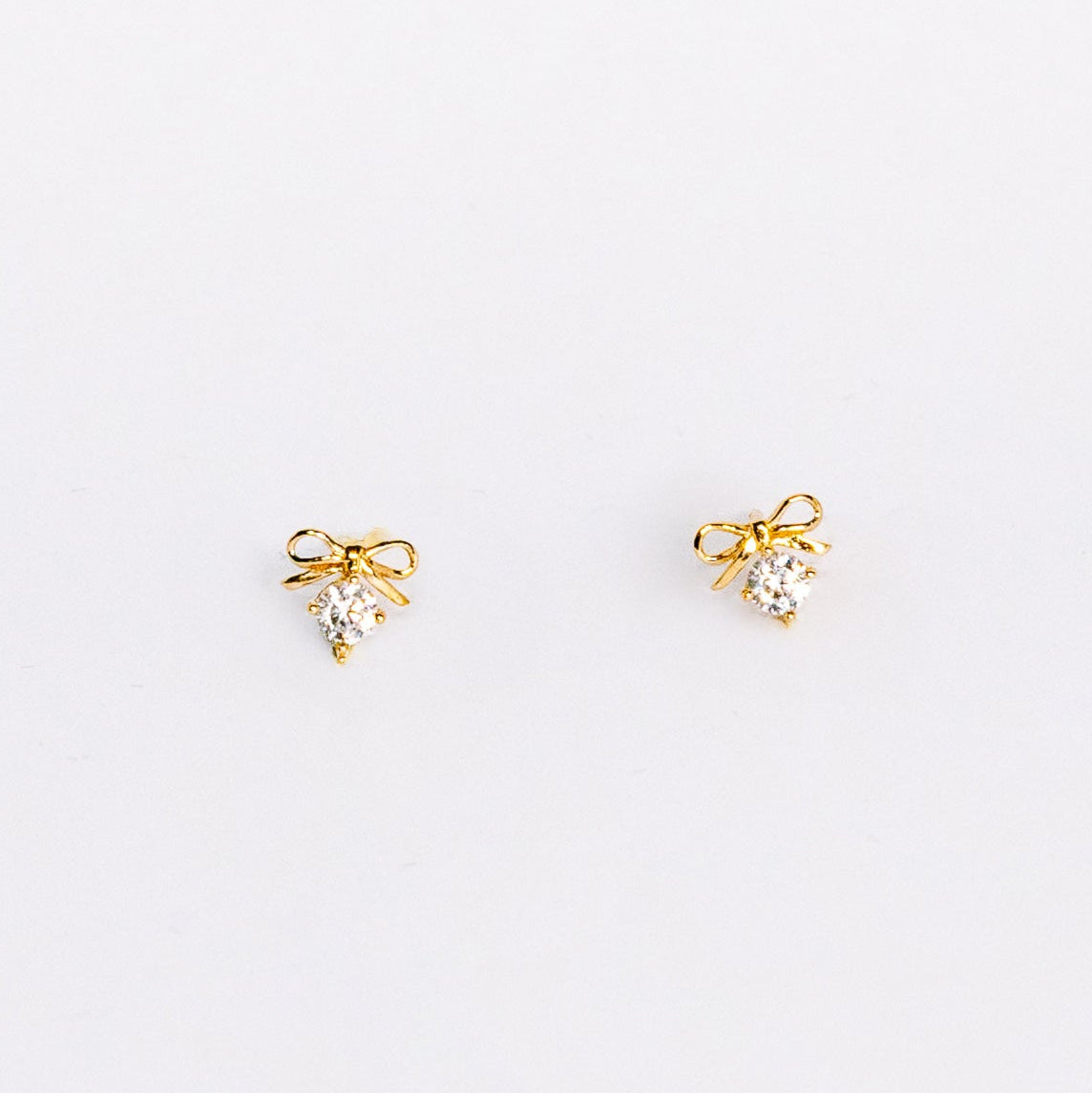 Pair of gold earrings on a light gray background