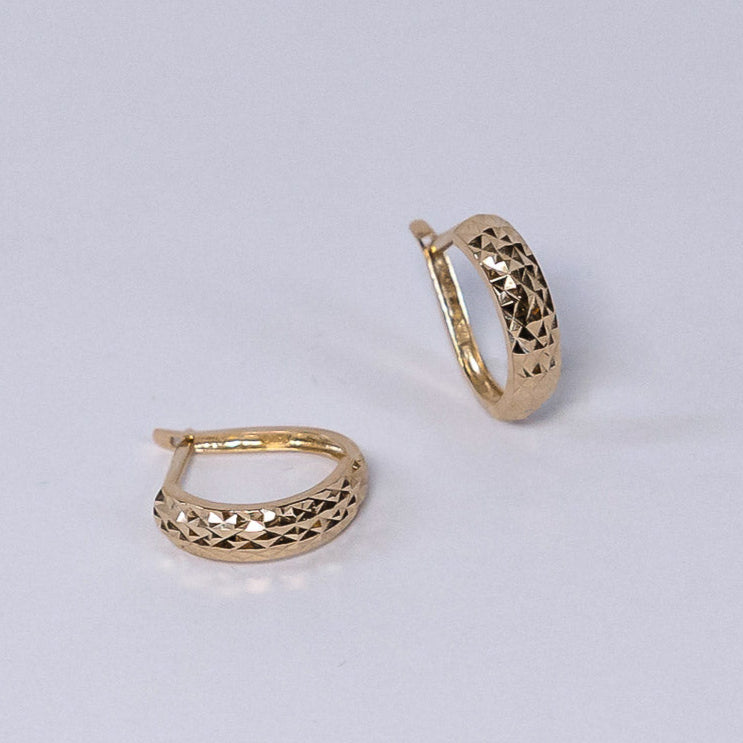 Gold hoop earrings on a light gray background