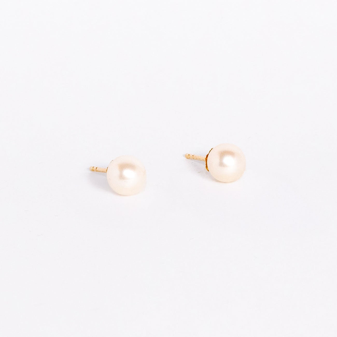 Pair of pearl stud earrings on a white background