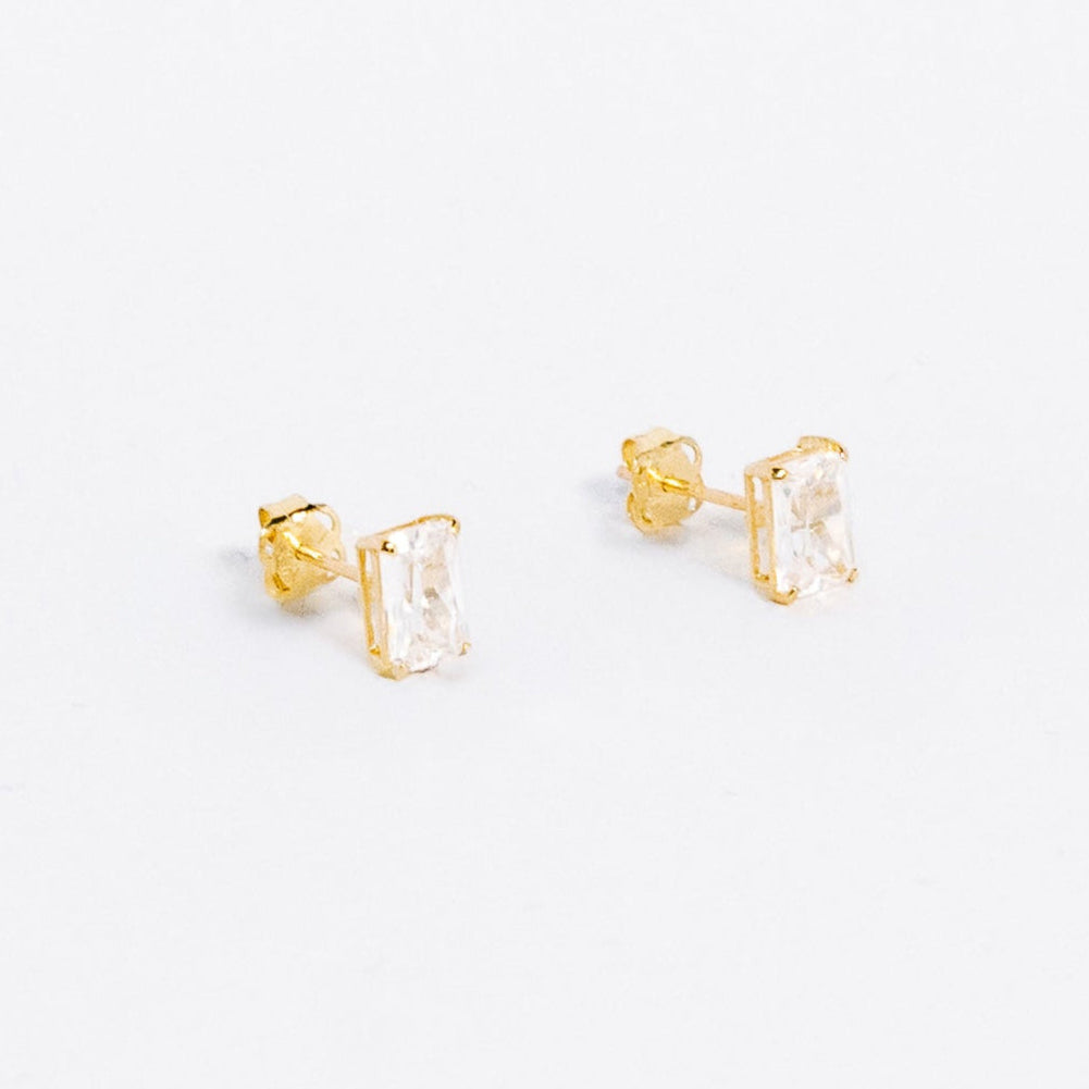 Gold stud earrings with clear gemstones on a white background