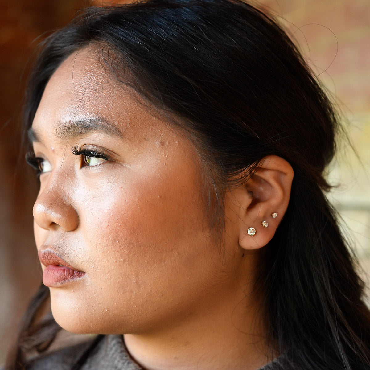 Close-up of a person with earrings against a blurred background