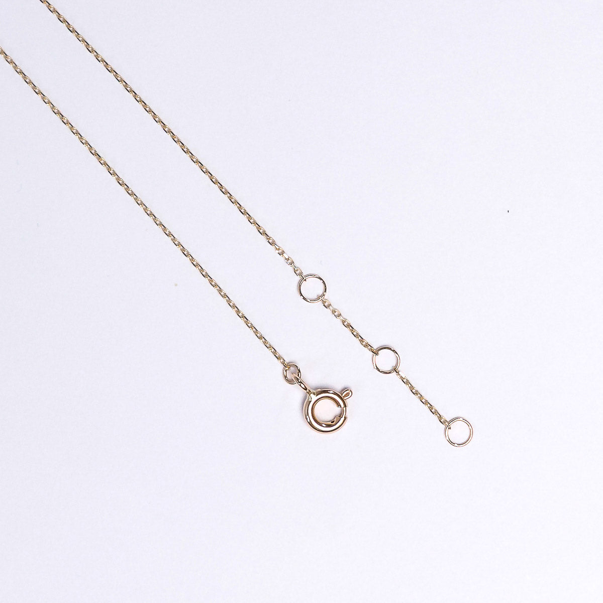 Rose gold necklace on a light gray background