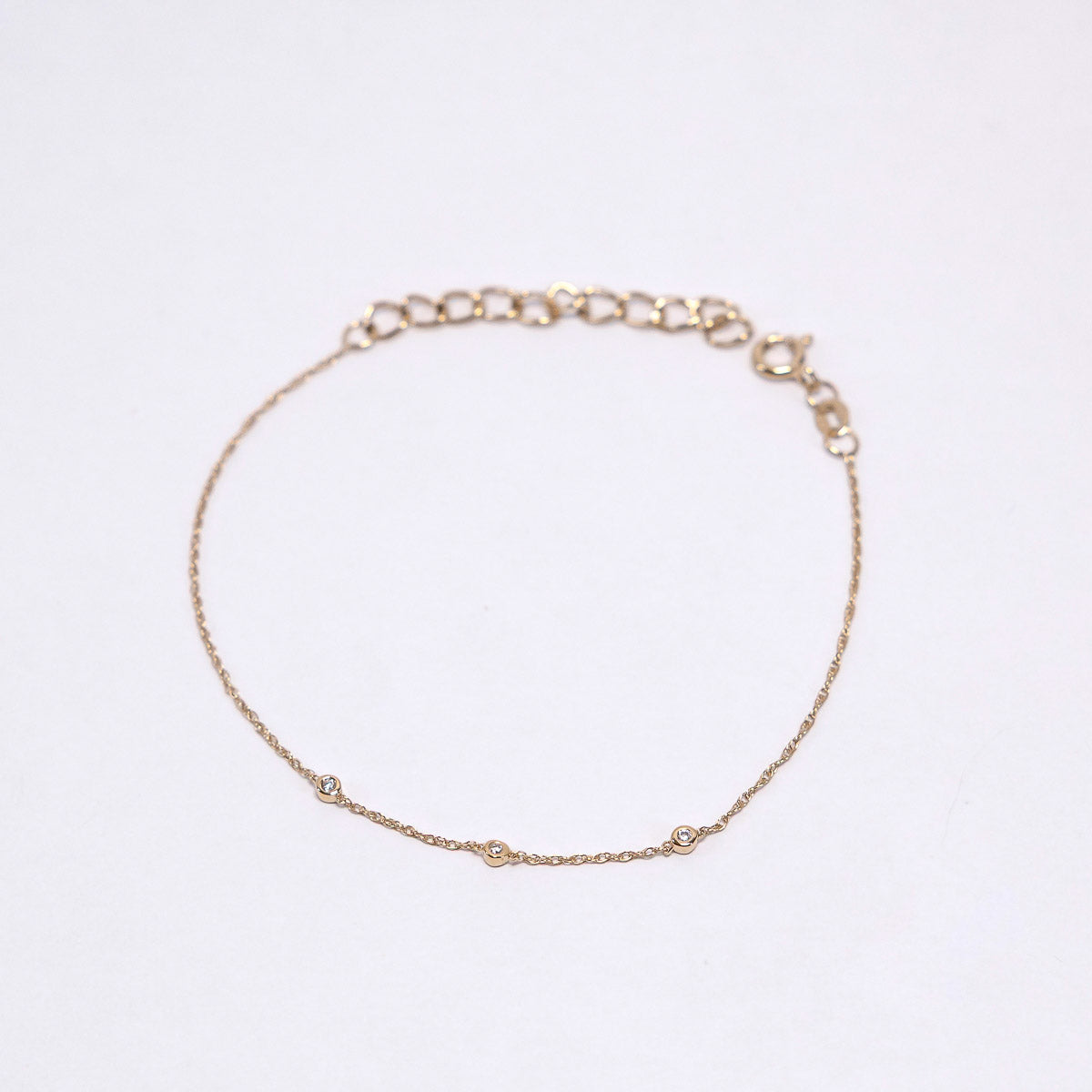 Gold bracelet on a light gray background