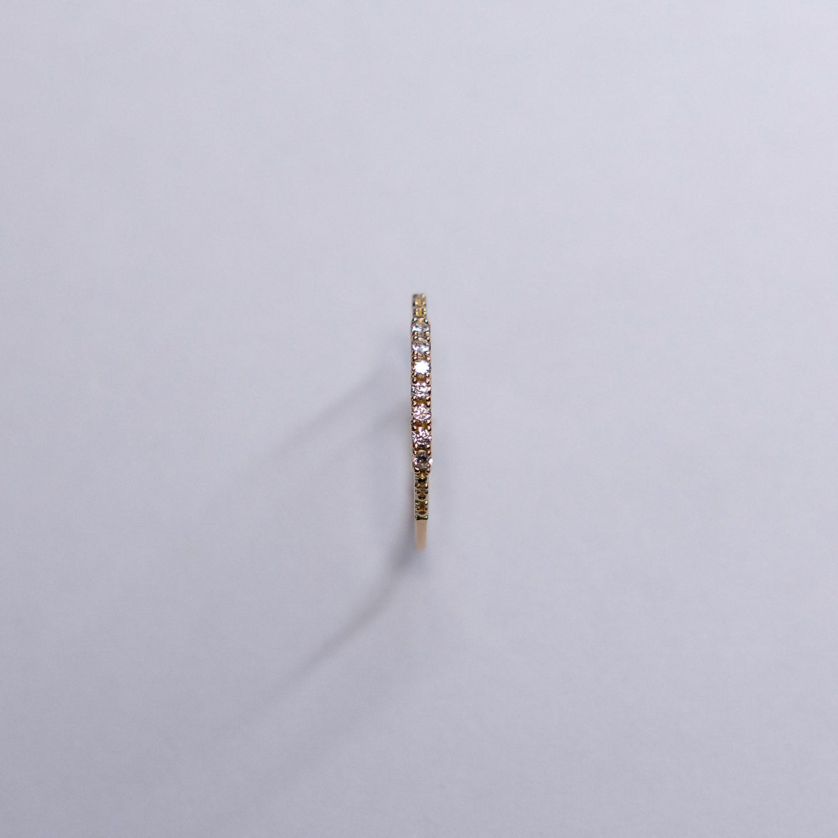 Gold ring with embedded stones on a light gray background