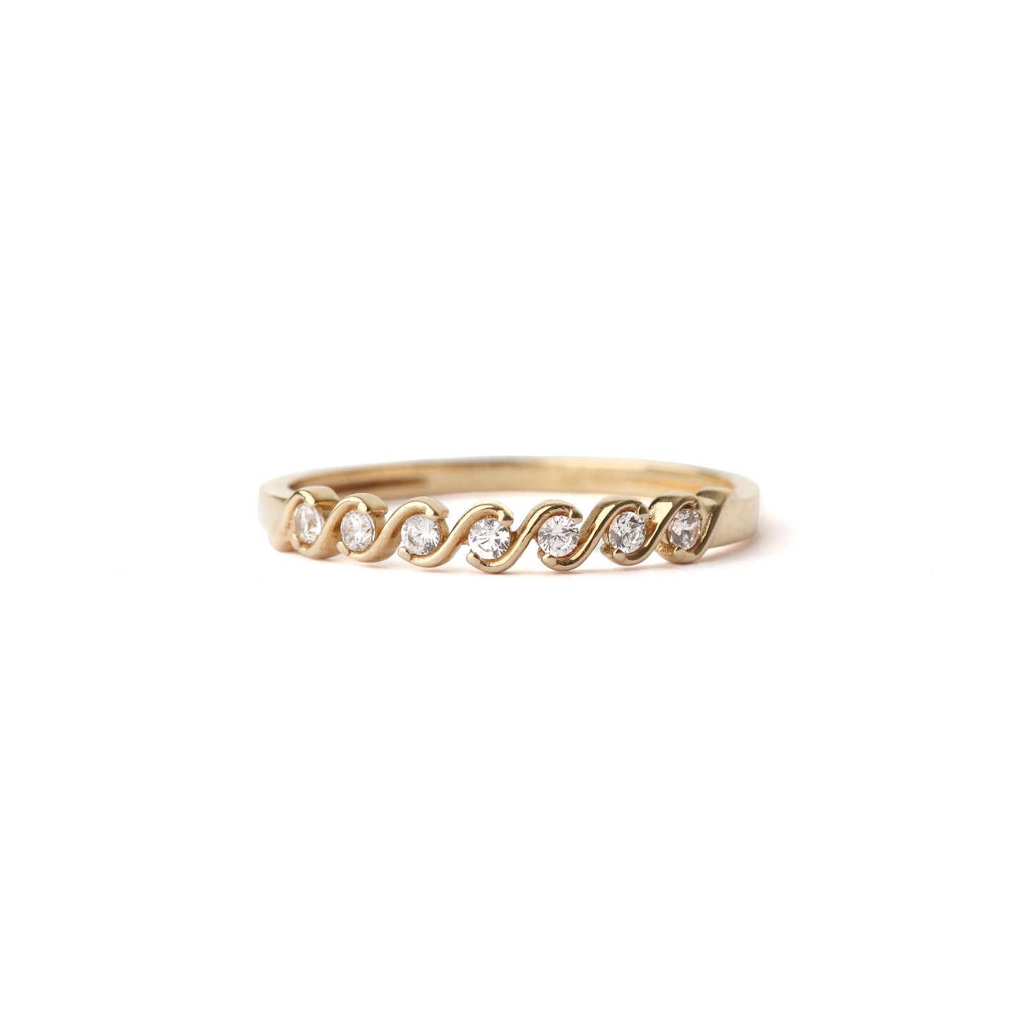 Women's solid yellow gold wave ring with small cubic zirconia gemstones set in the waves, displayed on a white background