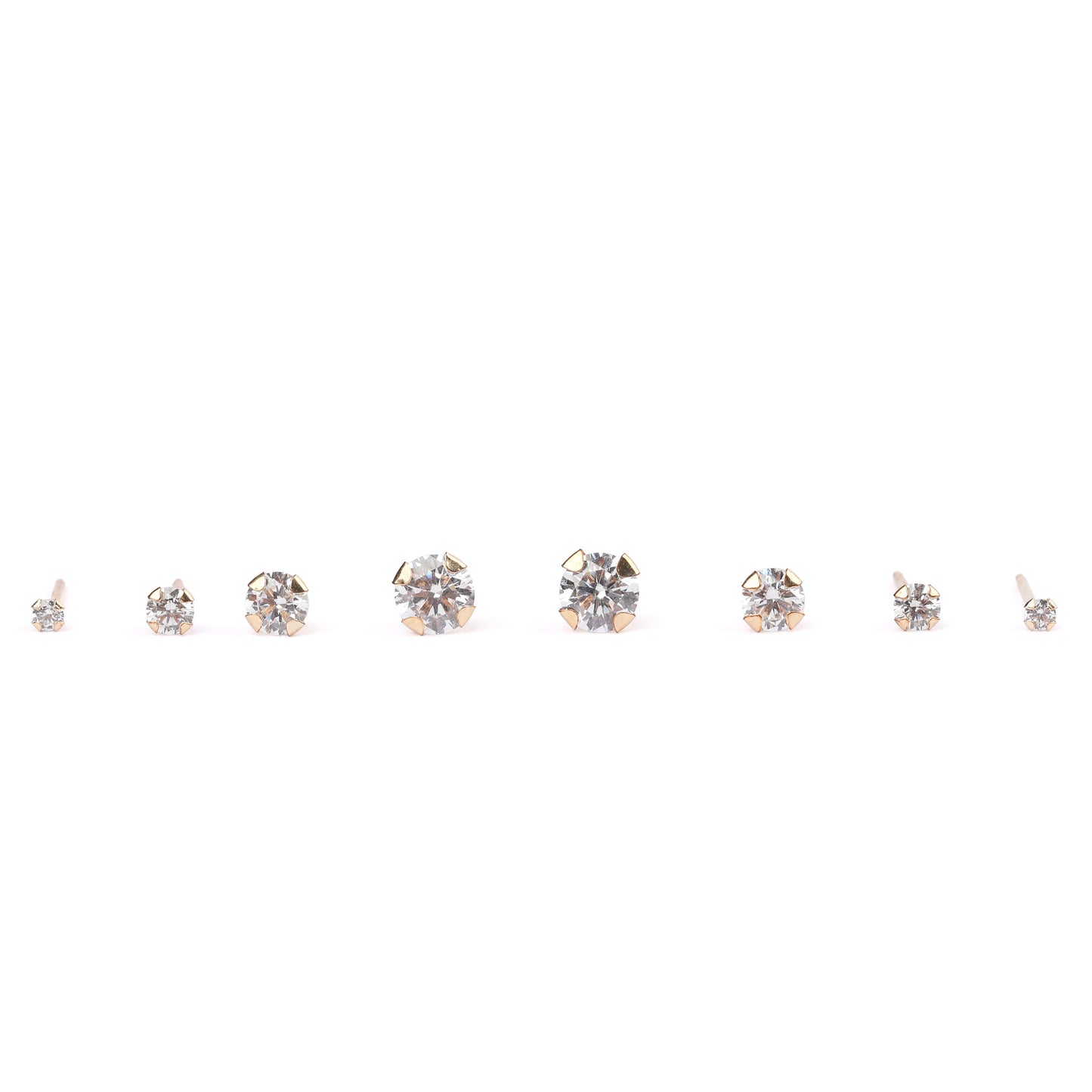 Four pairs of women's solid gold and cubic zirconia classic studs in mini, small, medium and large sizes on a white background