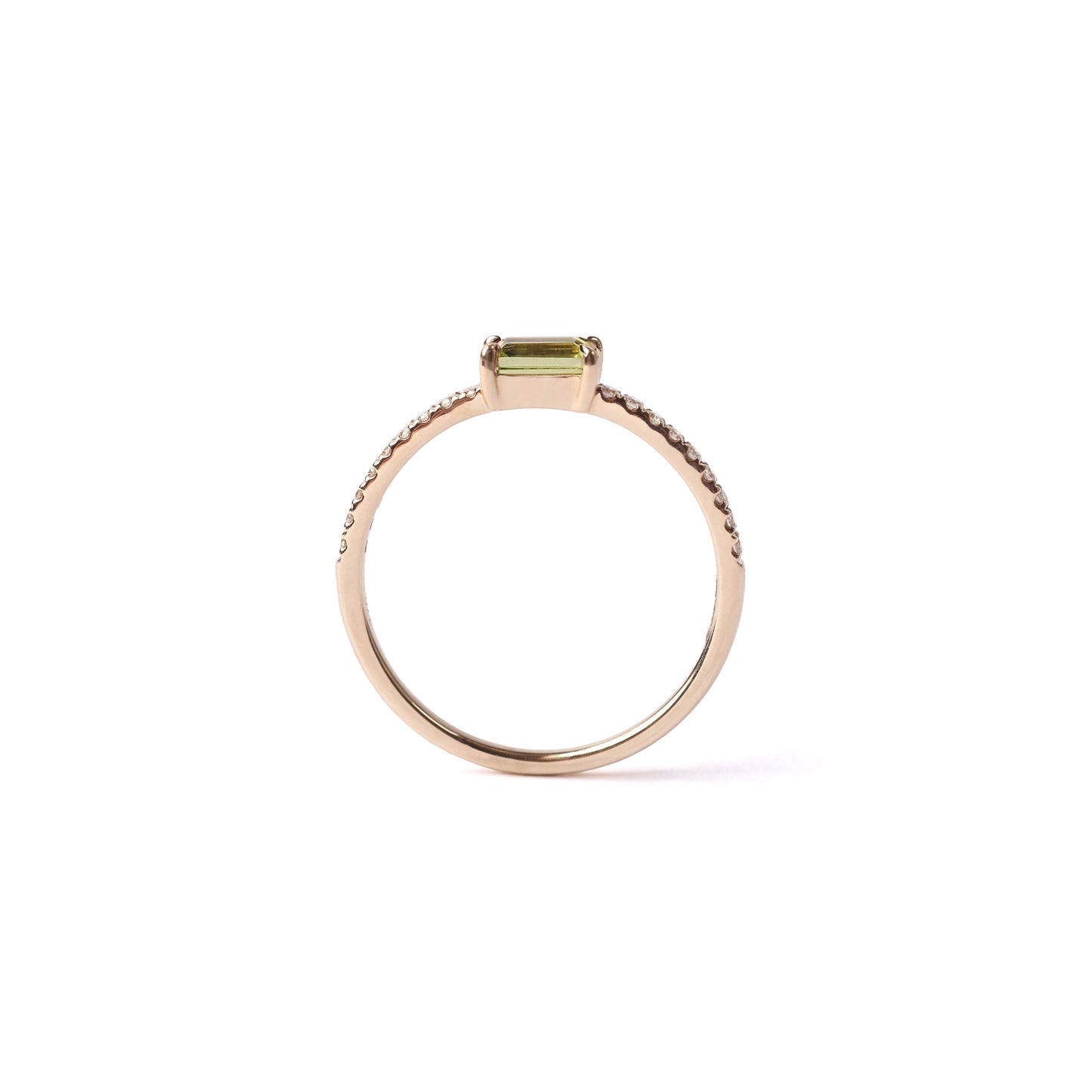 Women's solid yellow gold ring set with a central green peridot gemstone and small round diamonds on the shoulders each side of the peridot, displayed on a white background standing up sideways.