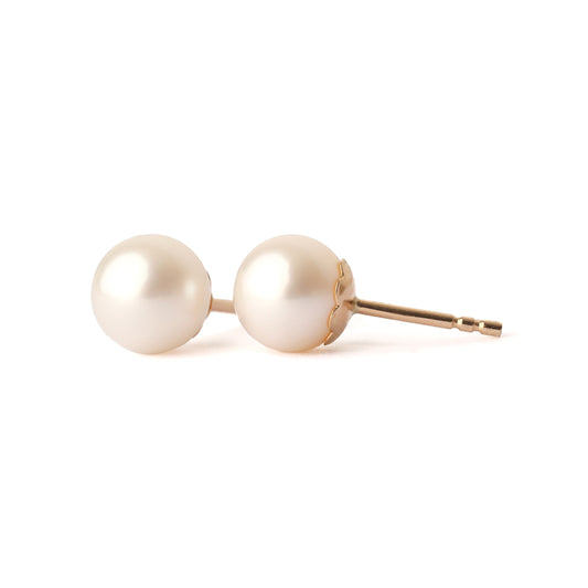 A pair of solid yellow gold and freshwater pearl earrings, classic size. One faces forward and the other is side on, both are set on a white background for the shopper to view.