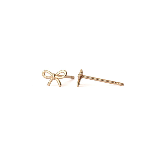 A pair of solid yellow gold bow studs, one facing forward the other sideways, set on a white background for the shopper to view.