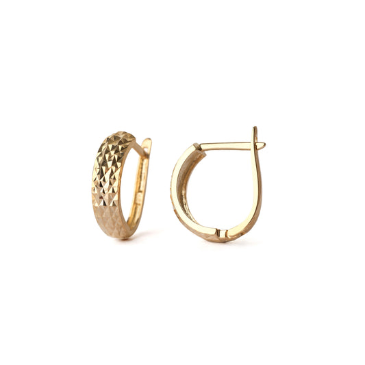 A pair of solid yellow gold huggie hoop earrings with a diamond cut design on the front. One is facing straight on and the other is side on, both are set on white background for the shopper to view.