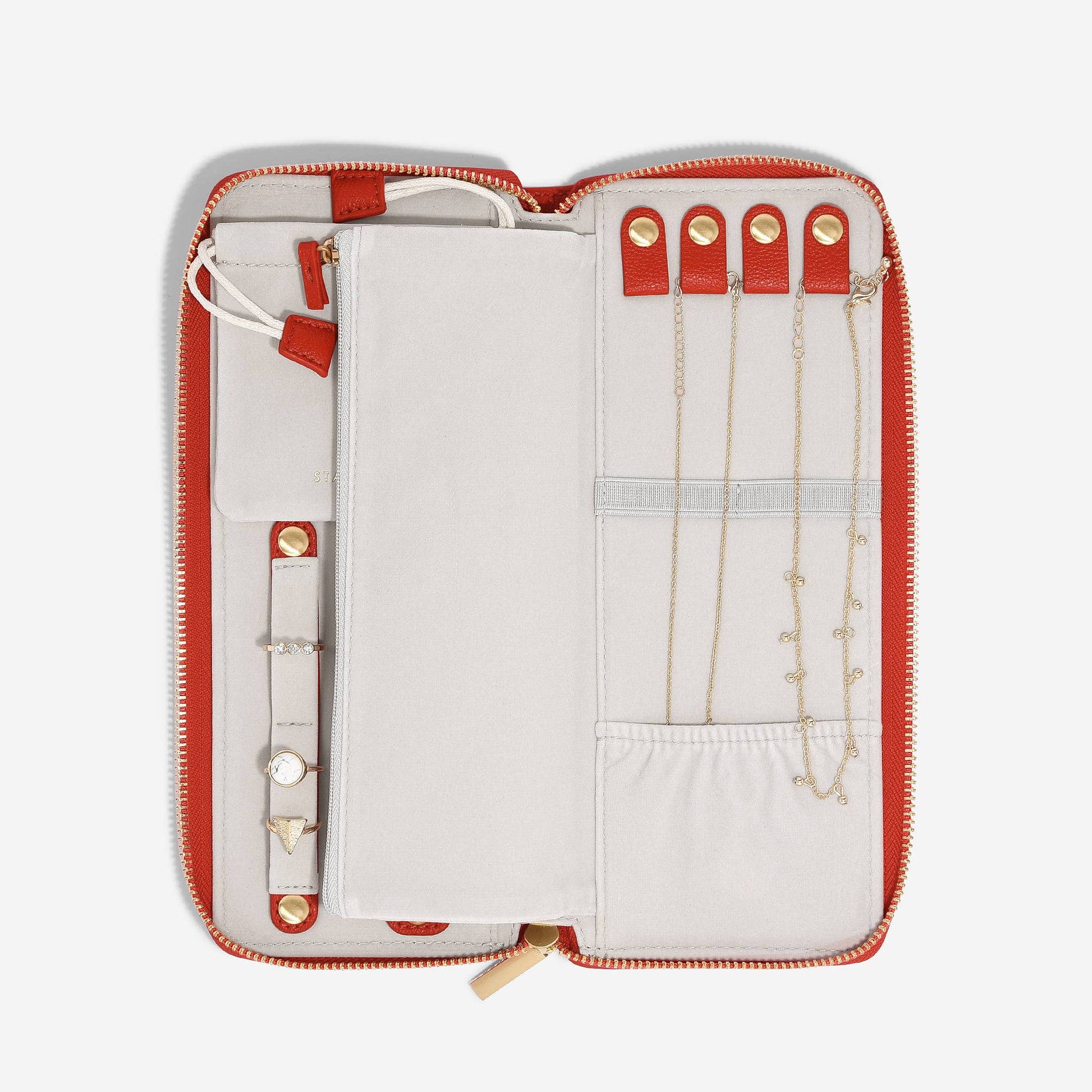 Jewelry organizer with red zipper and white interior displaying necklaces and bracelets.