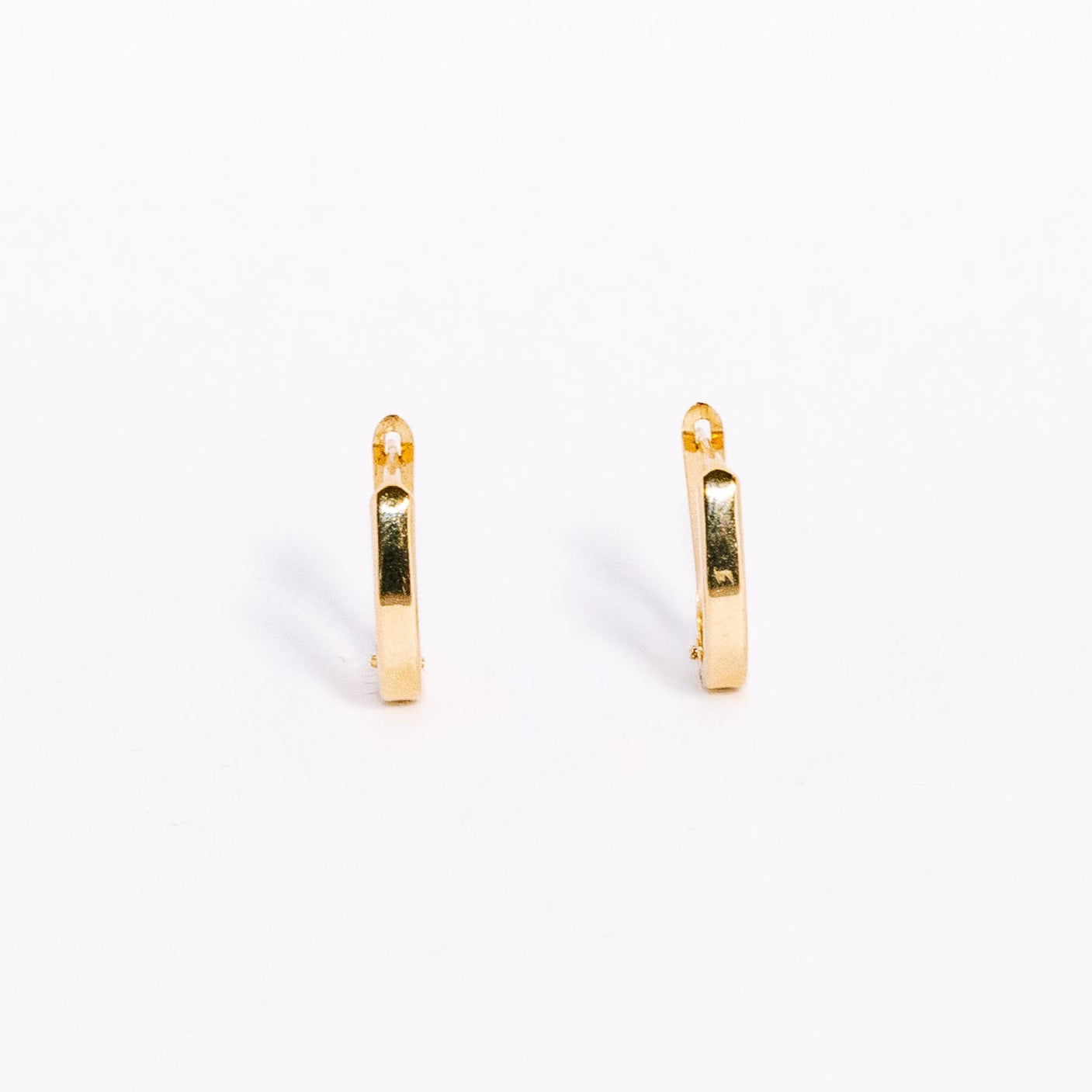 Two gold hoop earrings on a white background