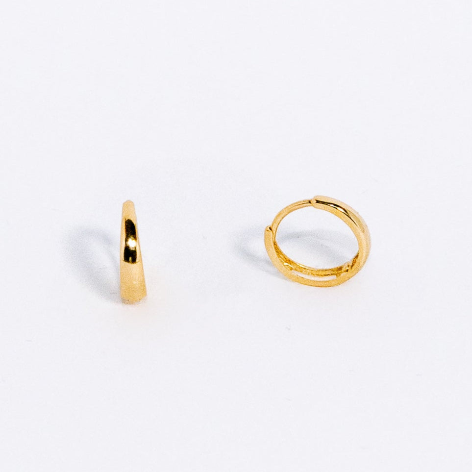 Two gold hoop earrings on a white background