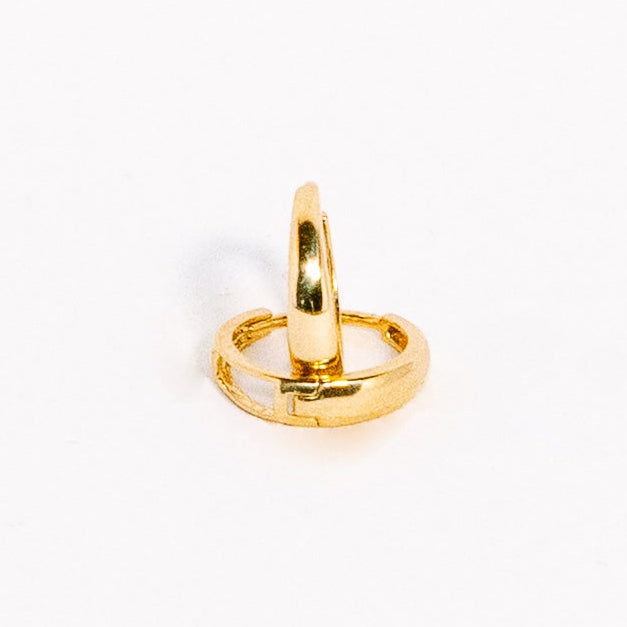 Gold ring charm on a white background