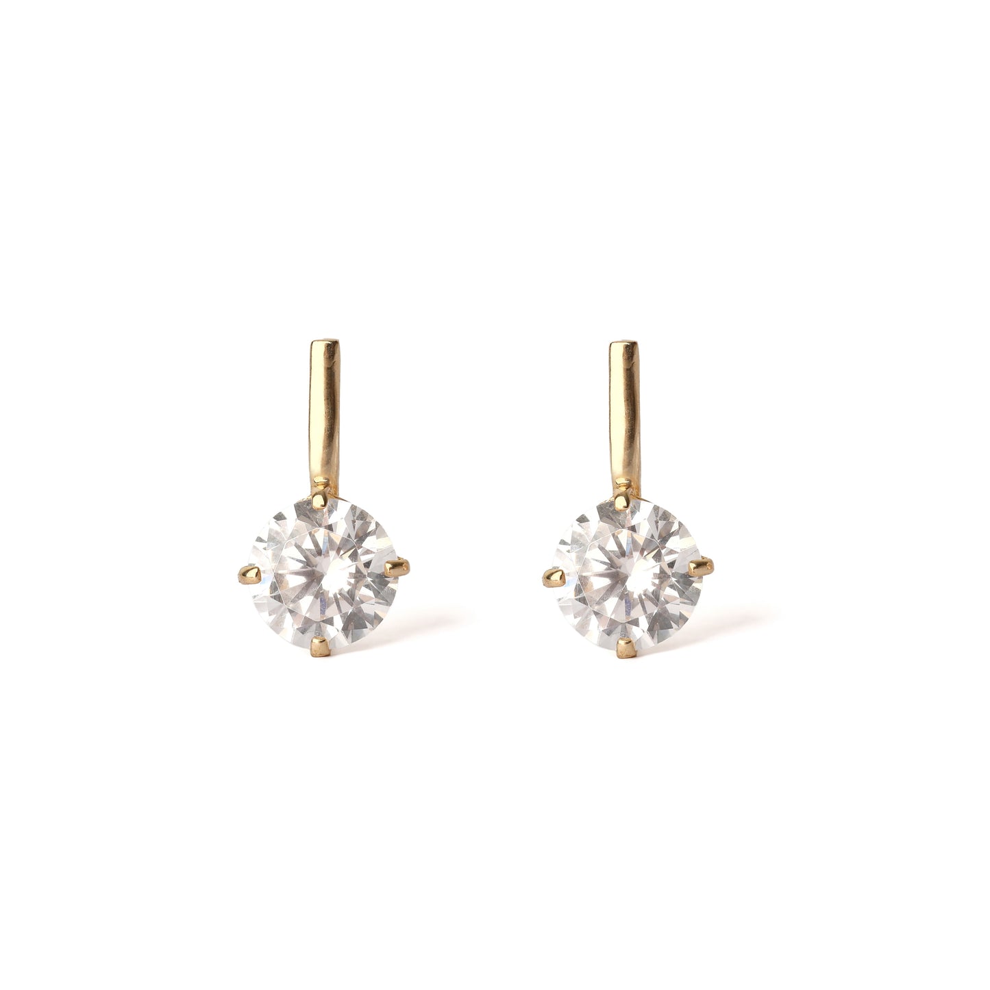 Pair of gold earrings with clear gemstones on a white background