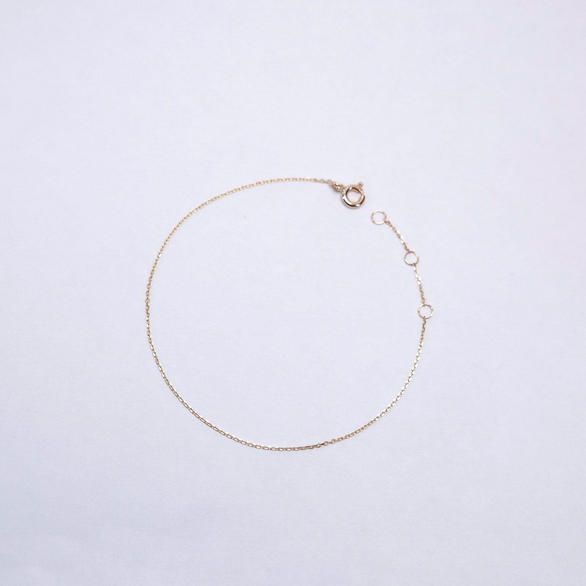 Gold bracelet on a light gray background
