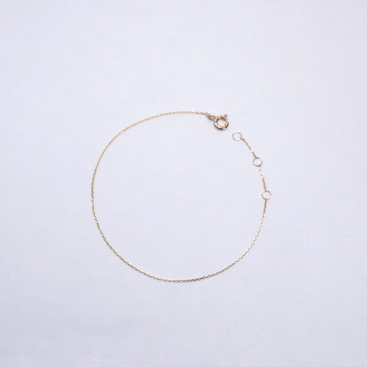 Gold bracelet on a light gray background
