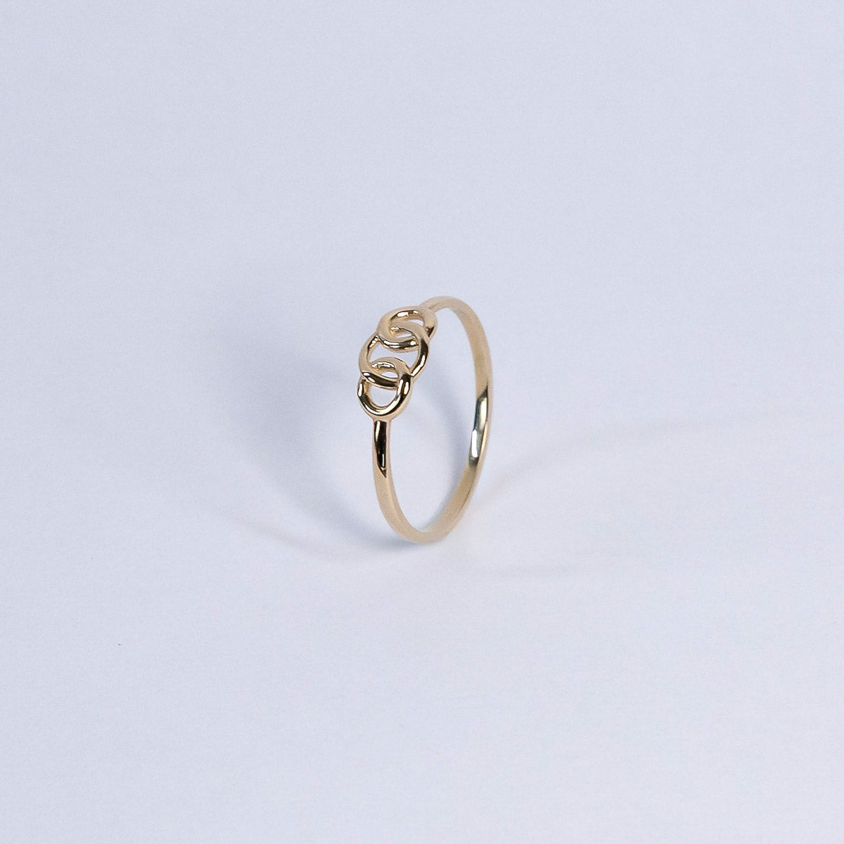 Gold ring with a unique design on a light gray background