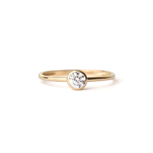 Gold ring with a diamond on a white background