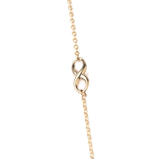 Women's 9K solid yellow gold bracelet with infinity symbol in the chain on a white background