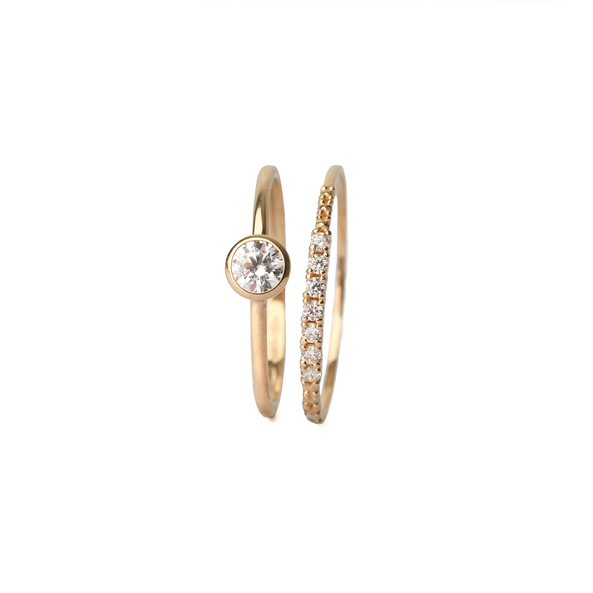 Two solid gold rings with cubic zirconia gemstones on a white background