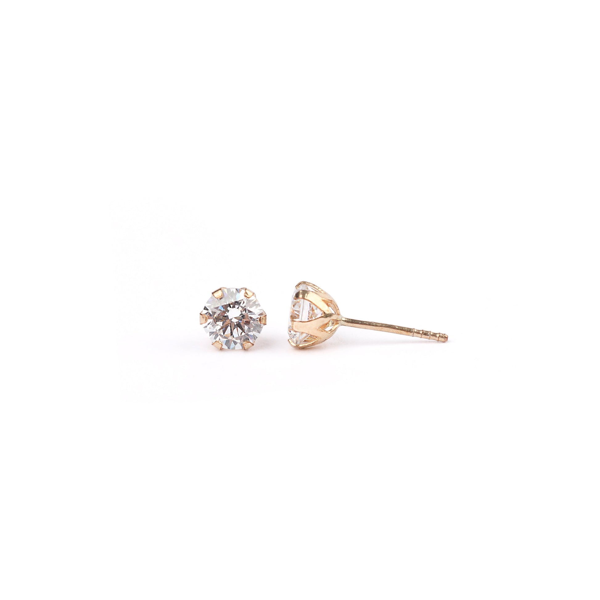 Pair of gold cubic zirconia stud earrings on a white background
