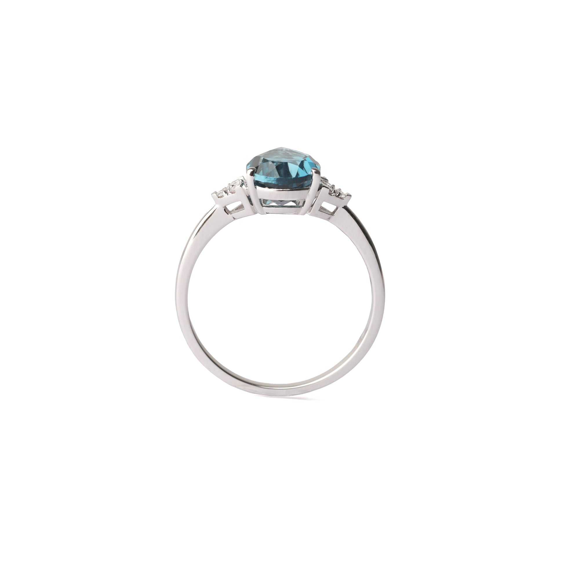 Women's white gold ring set with three small diamonds either side of a large pair shape London blue topaz gemstone, displayed on a white background.