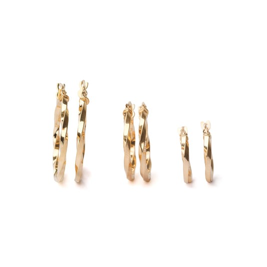Set of gold hoop earrings on a white background