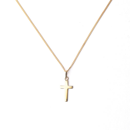 Gold cross necklace on a white background