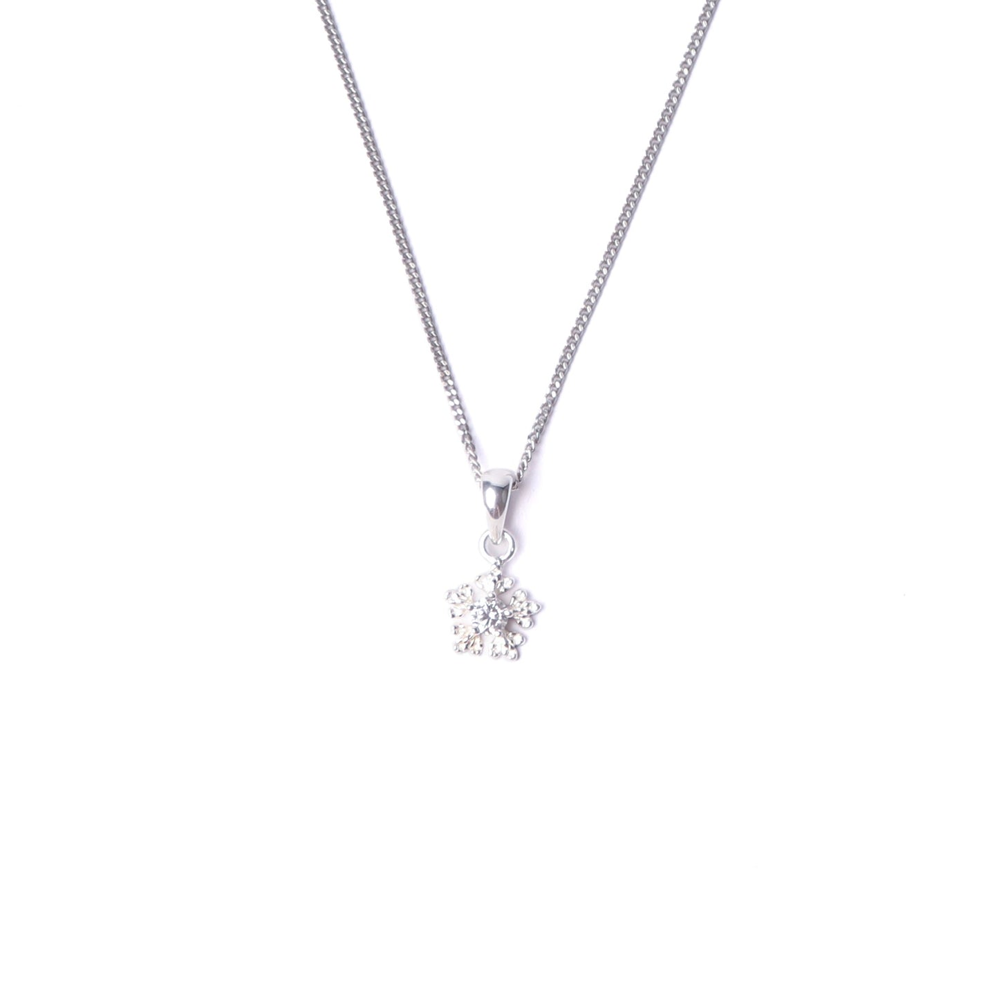 Women's sterling silver snowflake pendant necklace with small cubic zirconia gemstones on the pendant, hanging from a silver chain all set on a white background.