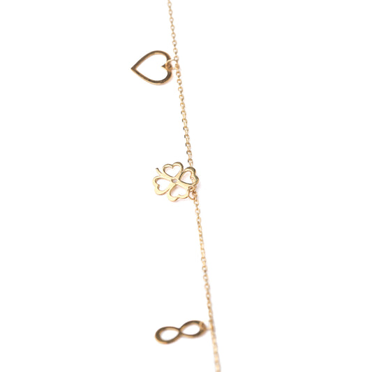 Women's solid gold lucky charm bracelet with heart, four-leaf clover and infinity symbols on a white background