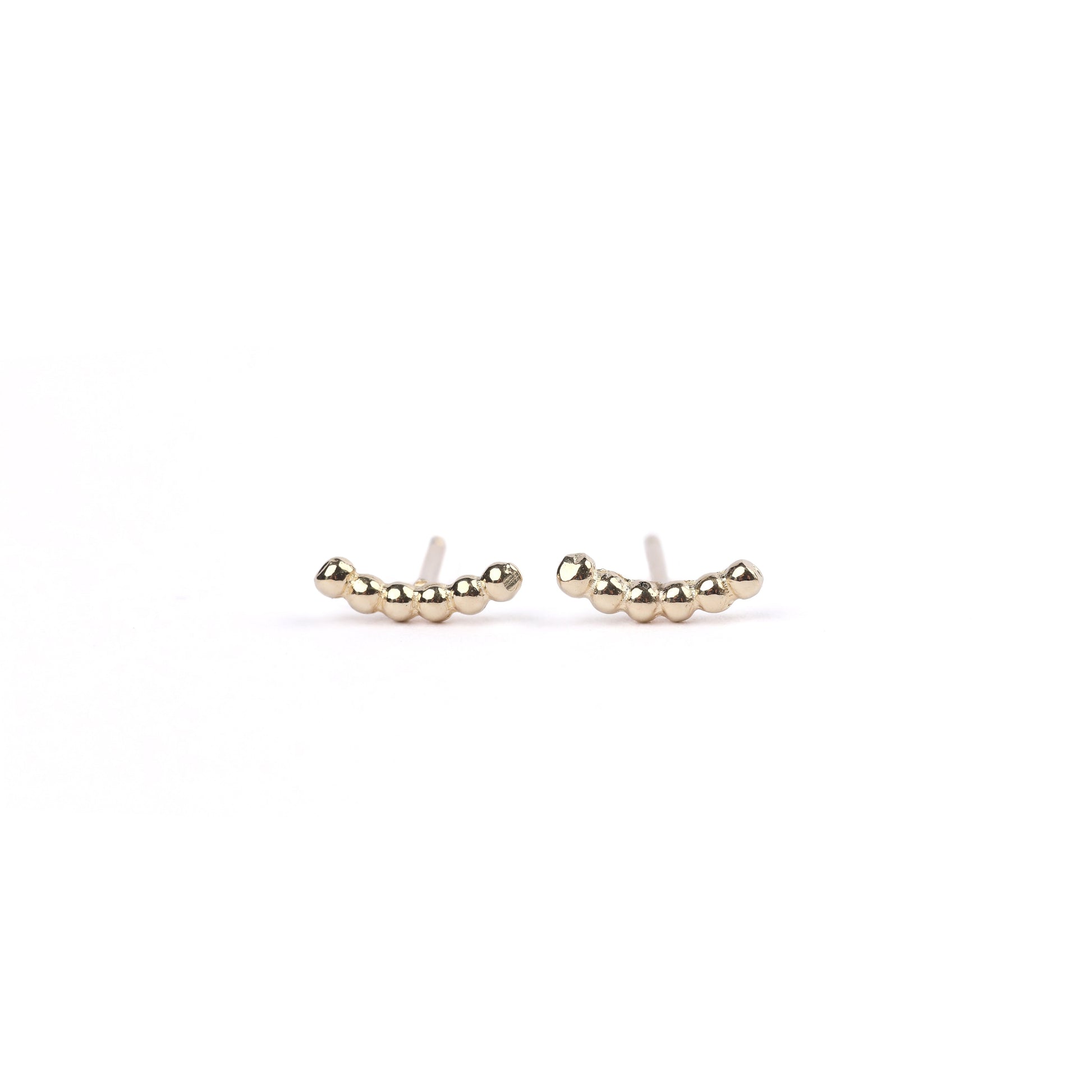 A pair of women's yellow gold bead climber stud earrings on a white background