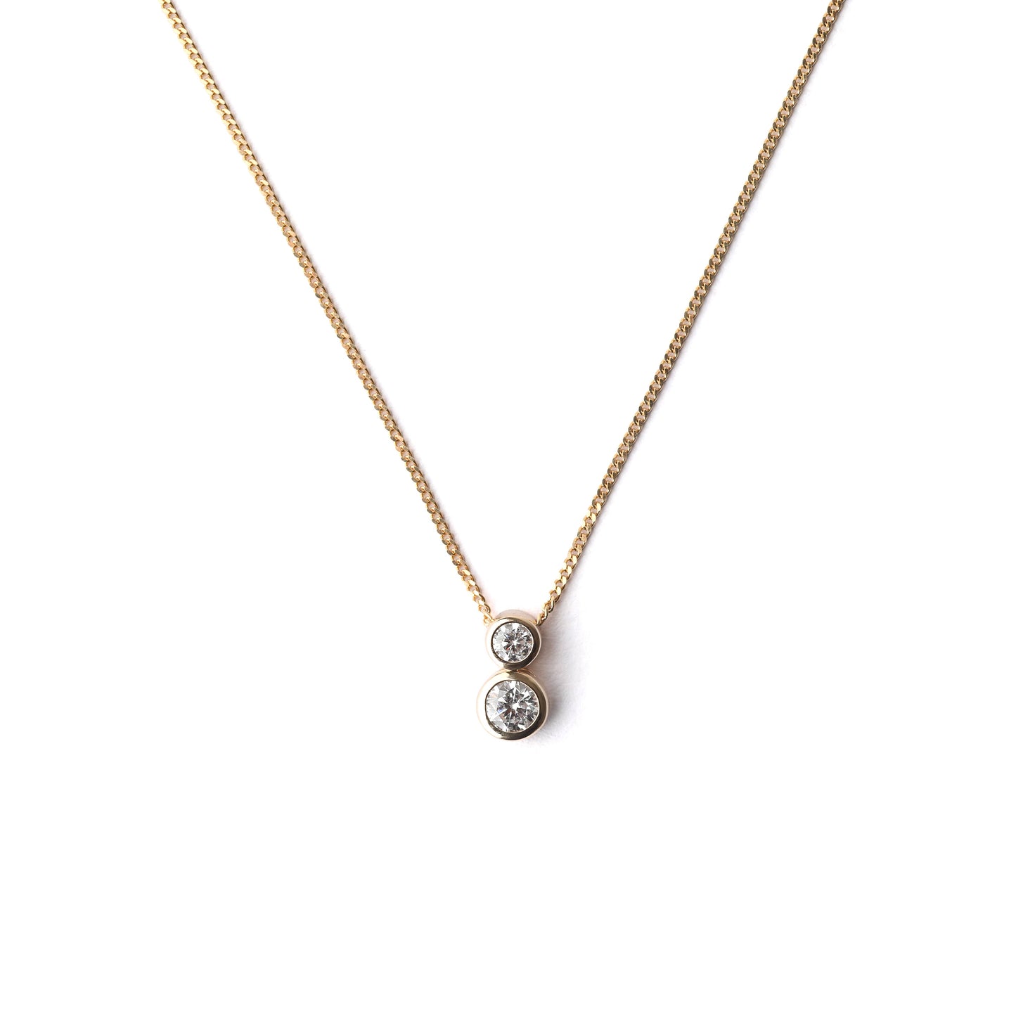 Women's delicate 9K solid yellow gold necklace with a two stone bezel-set cubic zirconia pendant on a white background