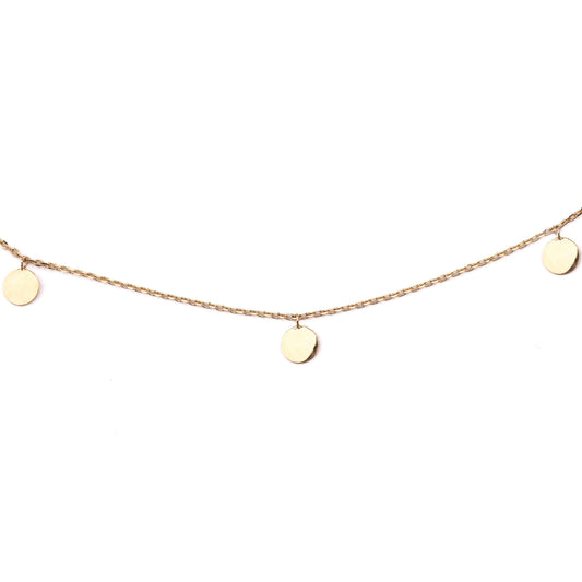 Women's solid gold necklace with three small round disks embelishing the chain on a white background