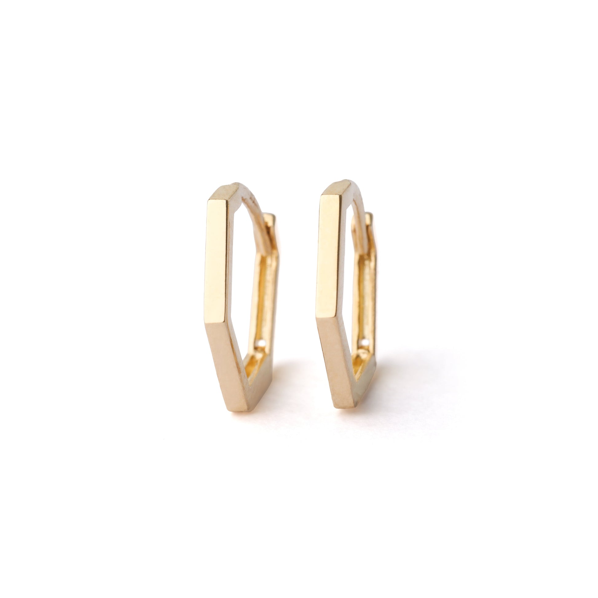 A pair of women's solid gold 13mm hexagonal hoop earrings on a white background