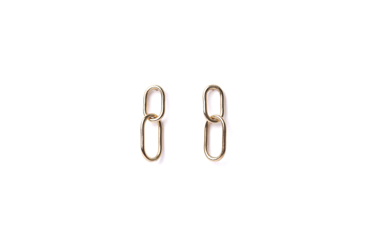 A pair of women's solid gold paperclip drop earrings on a white background