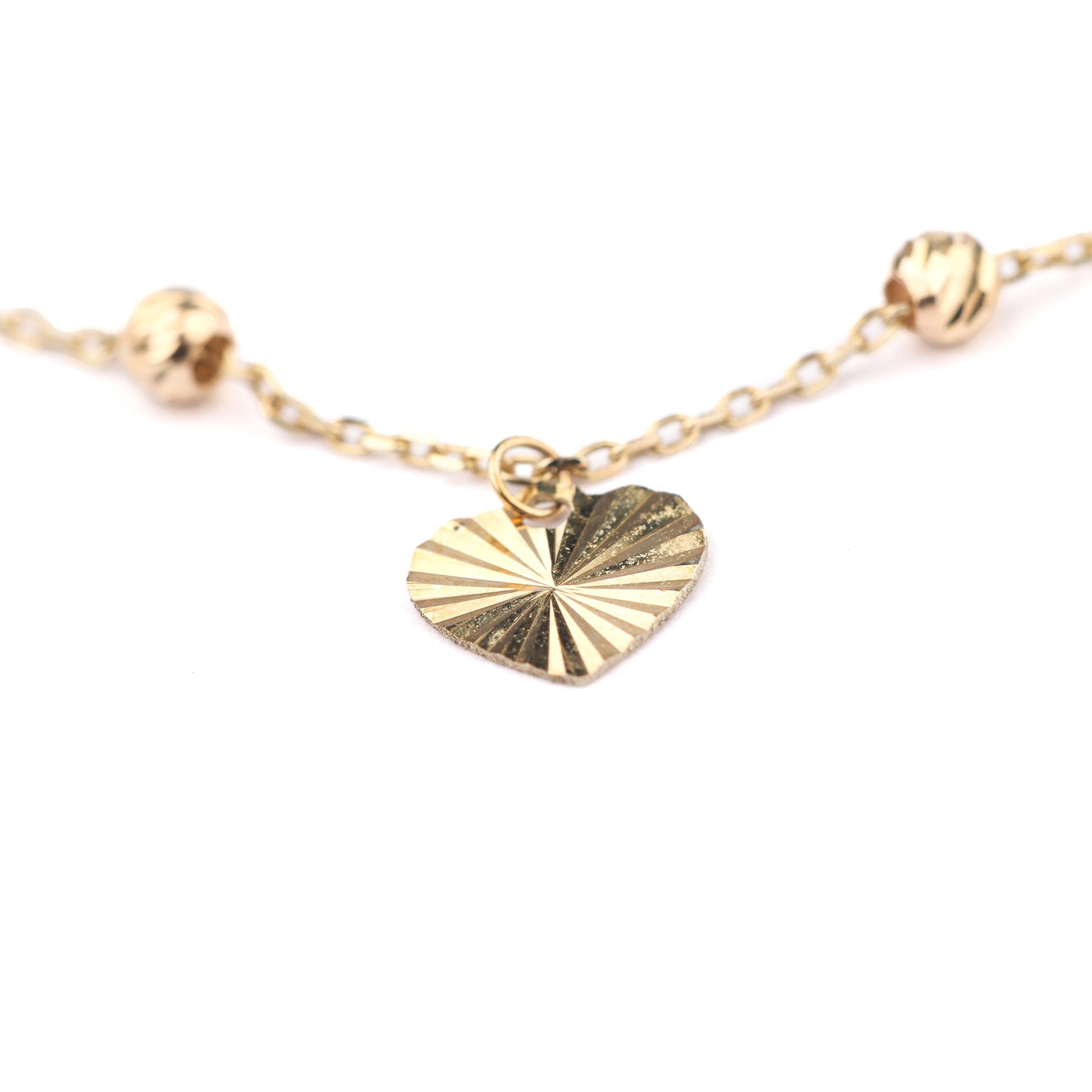 Women's 9K solid yellow gold brcelet with a detailed heart pendant on a white background
