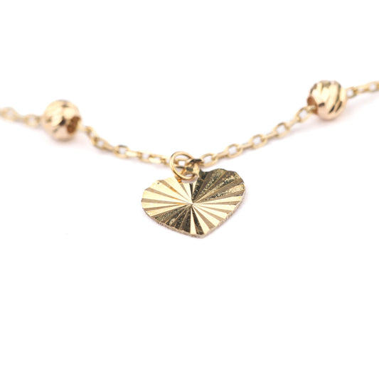 Women's 9K solid yellow gold brcelet with a detailed heart pendant on a white background