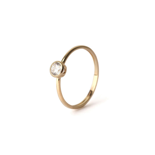 Women's solid yellow gold bezel-set cubic zirconia ring displayed on a white background 