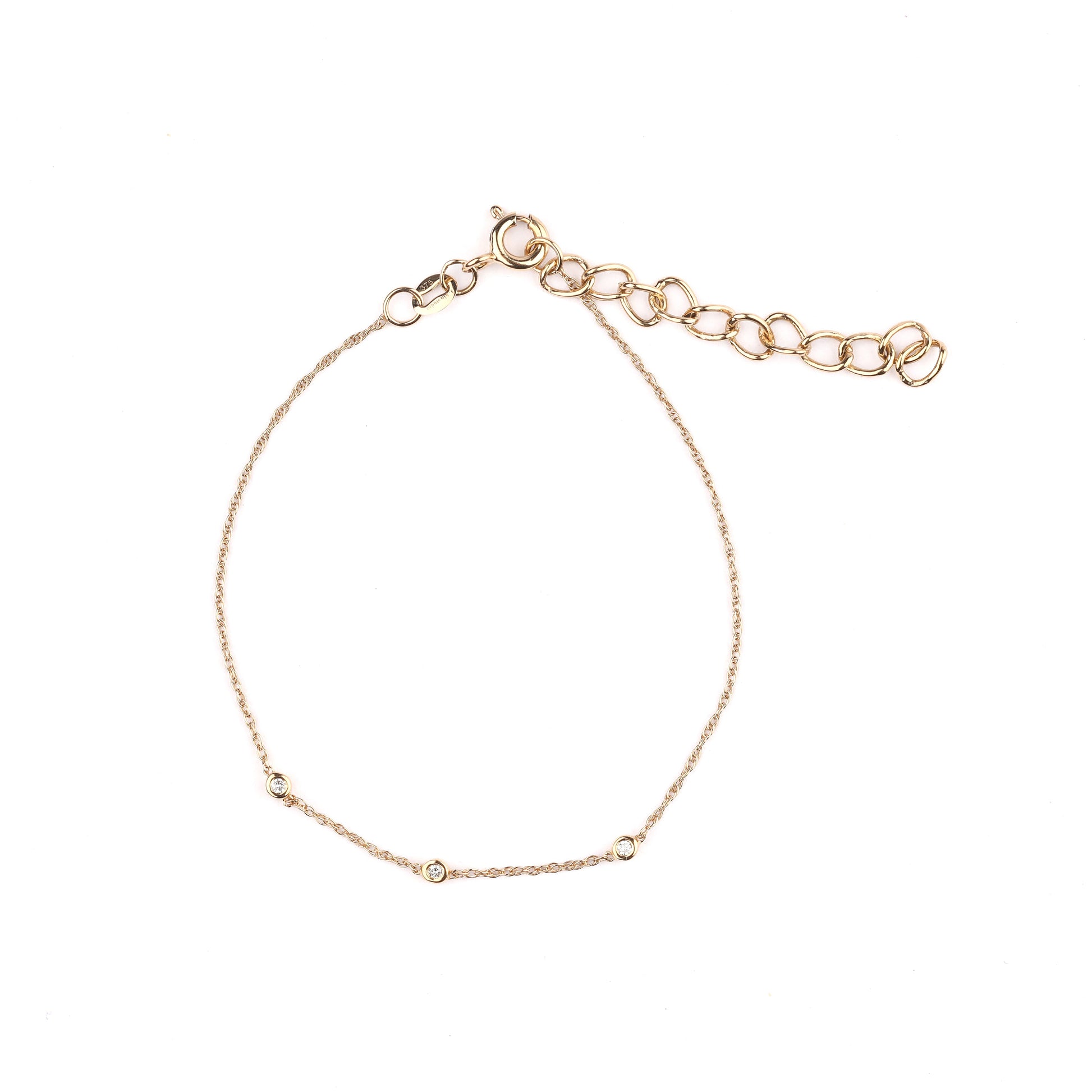 Women's solid gold and trio of bezel-set diamonds bracelet on a white background
