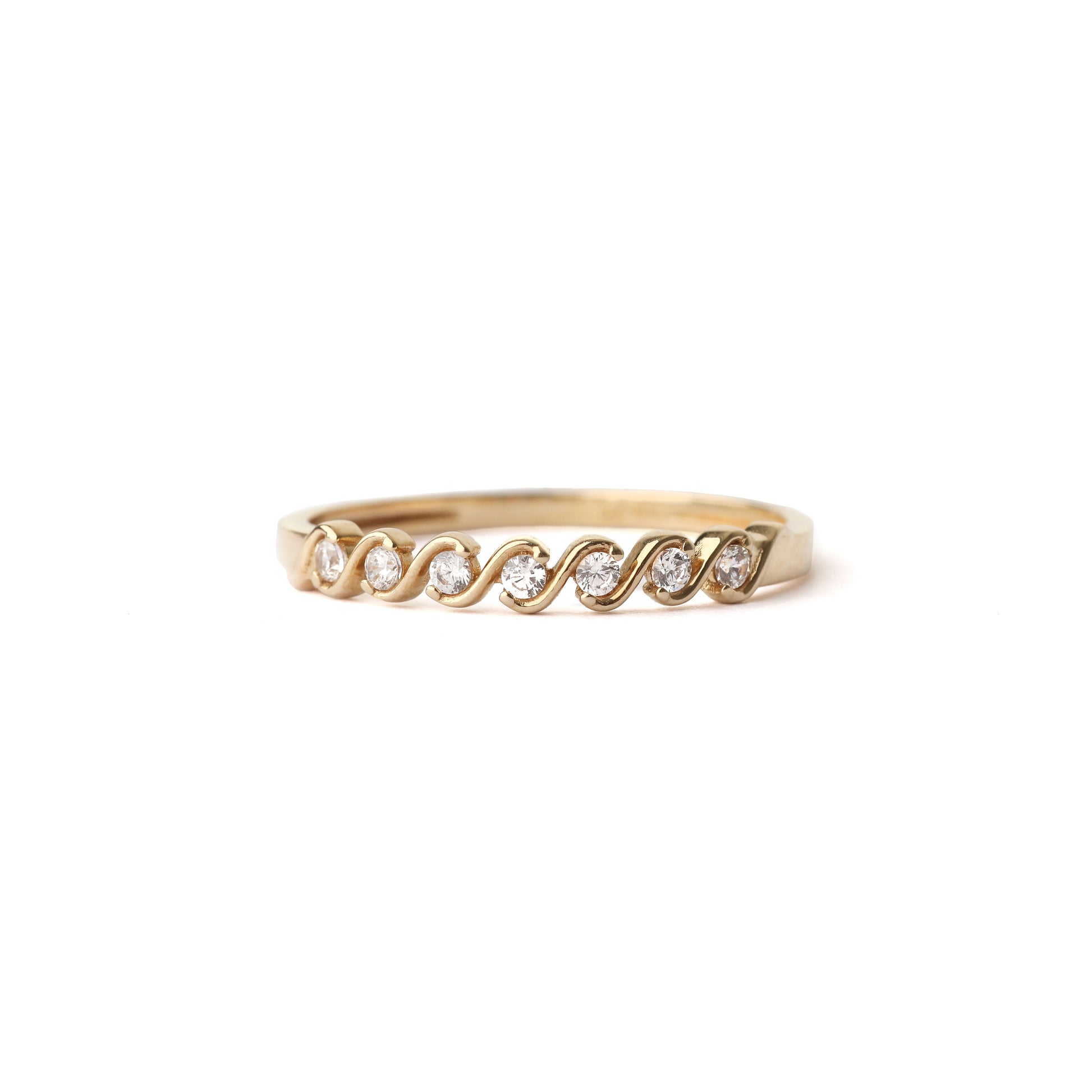 Women's solid yellow gold wave ring with small cubic zirconia gemstones set in the waves, displayed on a white background