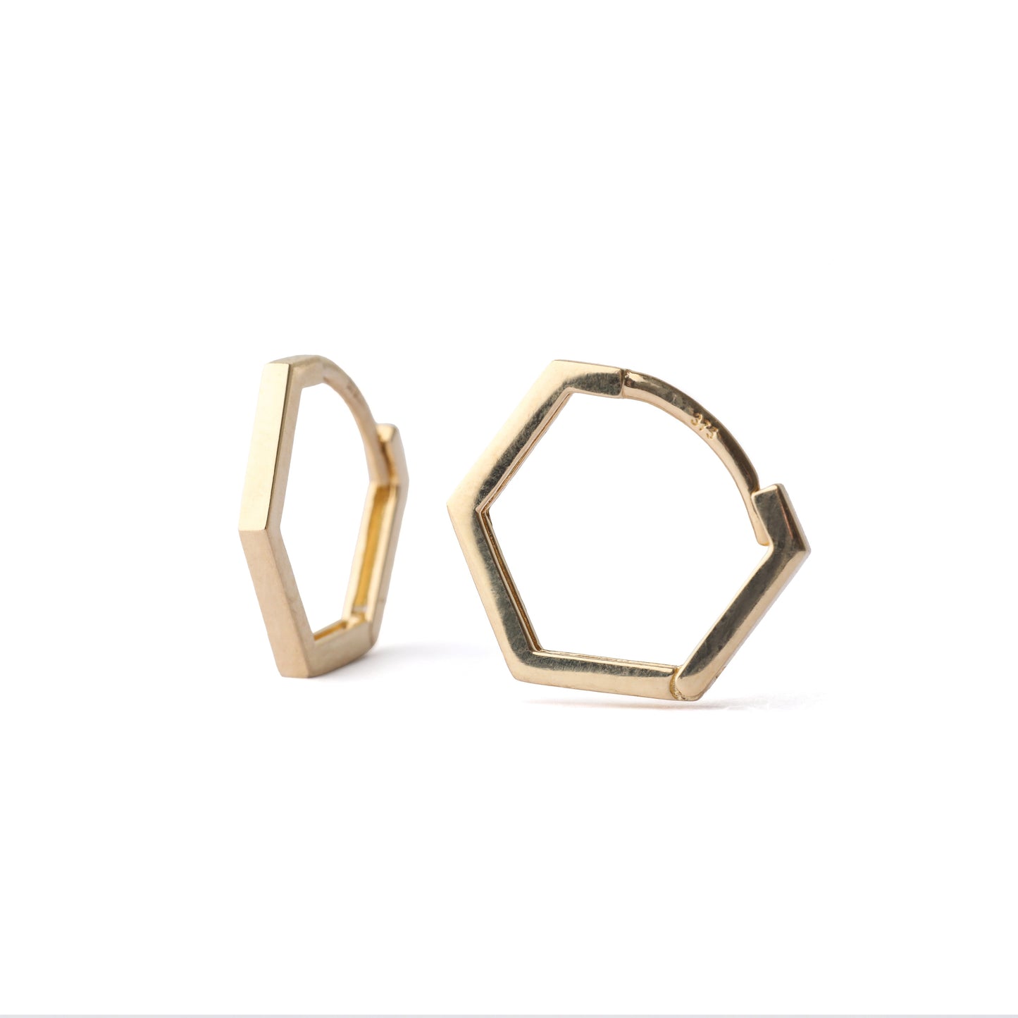 A pair of women's solid gold 13mm hexagonal hoop earrings on a white background