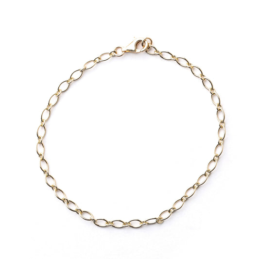Women's solid gold trace chain bracelet on a white background