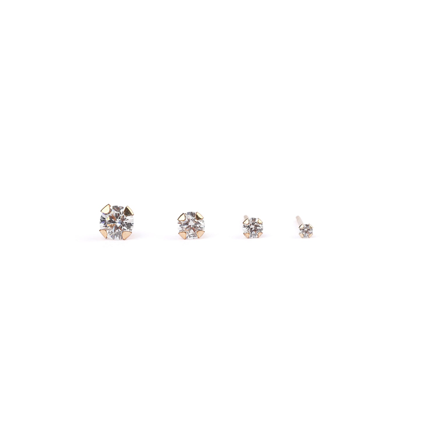 Four single studs from four pairs of women's classic solid gold and cubic zirconia stud earrings in mini, small, medium and large sizes on a white background