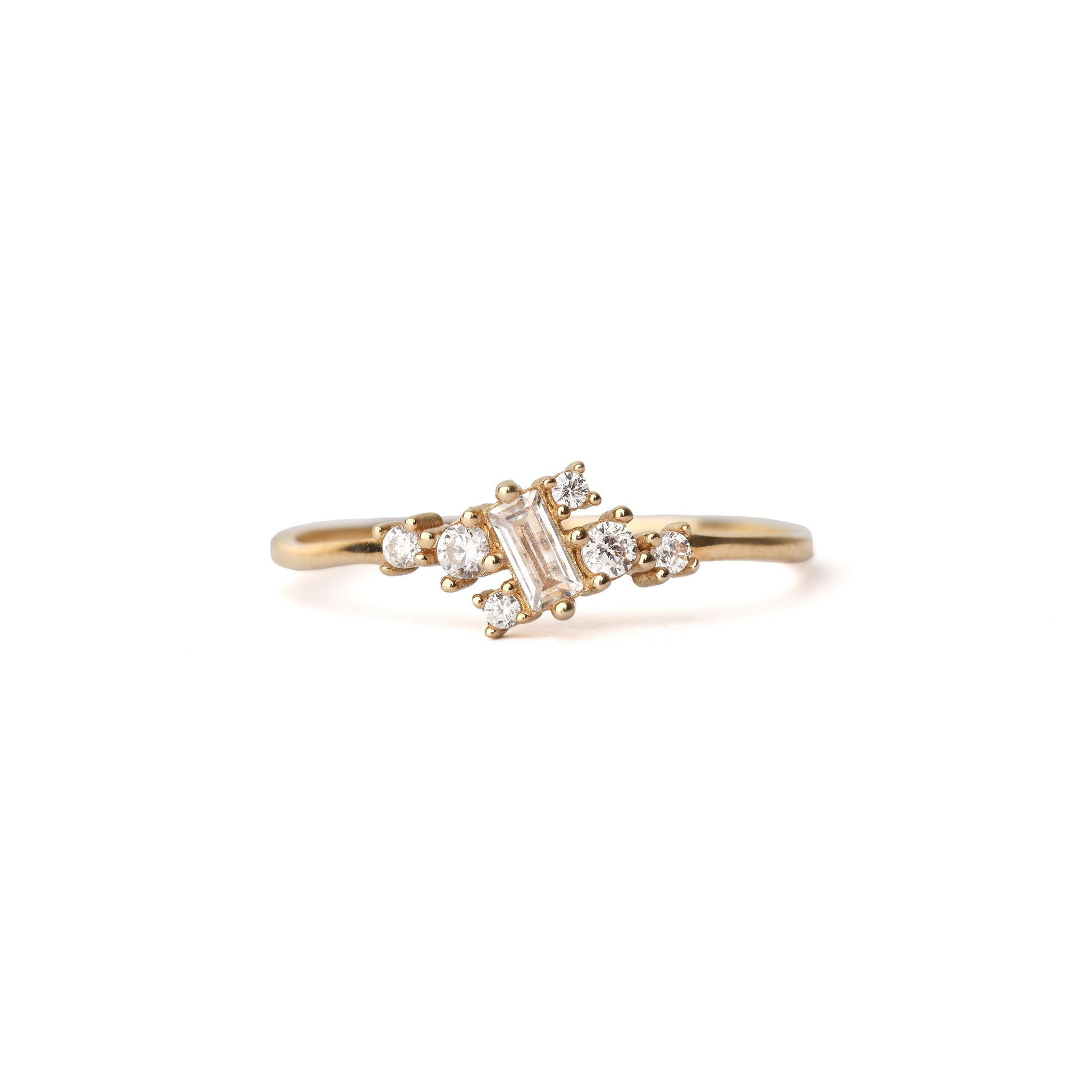 Women' solid yellow gold ring set with six round cubic zirconia gemstones equally placed either side of a baguette shape cubic zirconia gemstone, displayed on white background