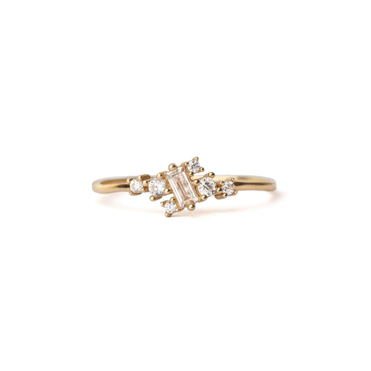 Women' solid yellow gold ring set with six round cubic zirconia gemstones equally placed either side of a baguette shape cubic zirconia gemstone, displayed on white background