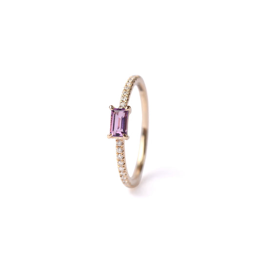 Women's solid yellow gold ring set with a central purple amethyst gemstone and small round diamonds on the shoulders each side of the amethyst, displayed on a white background standing up facing frontwards.