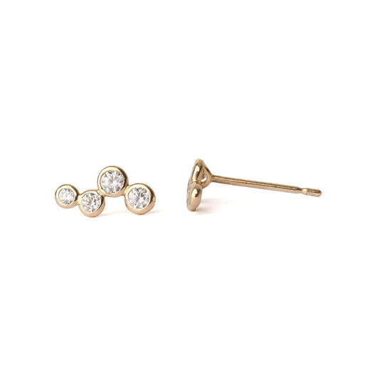 A pair of solid yellow gold bezel-set cubic zirconia earrings. Each earring has four cubic zirconia gemstones of various sizes. One earring is face on and the other is sideways and both are set on a white background for the shopper to view.